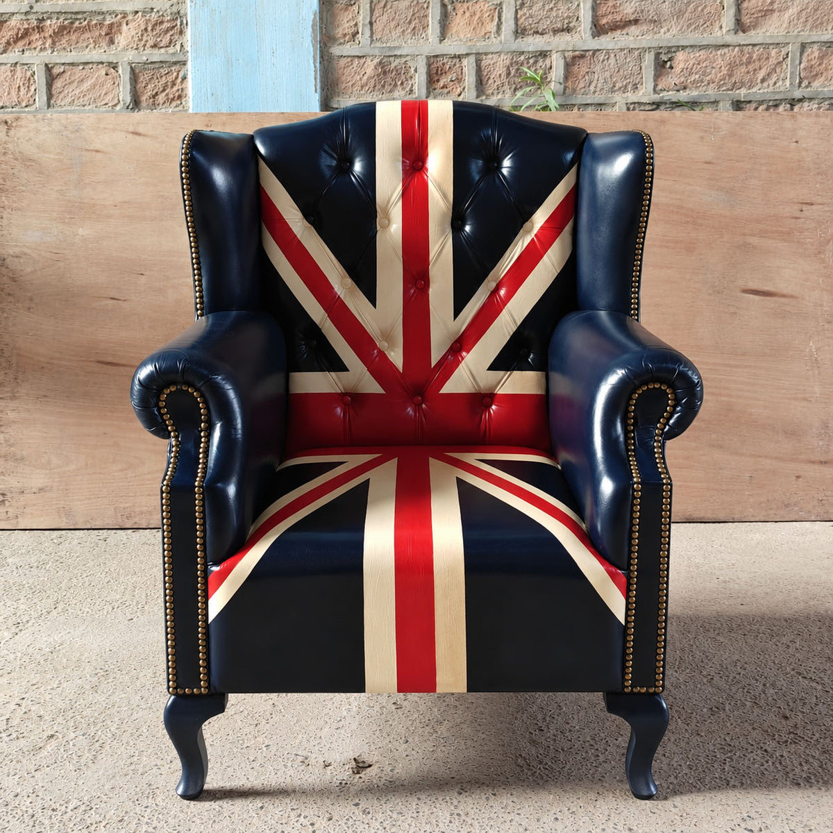 The Britannia Union Jack Chesterfield wingback armchair in genuine buffalo leather, featuring a hand-painted British flag, deep button tufting and brass studs.
