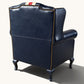 The Britannia Union Jack Chesterfield wingback armchair in genuine buffalo leather, featuring a hand-painted British flag, deep button tufting and brass studs.
